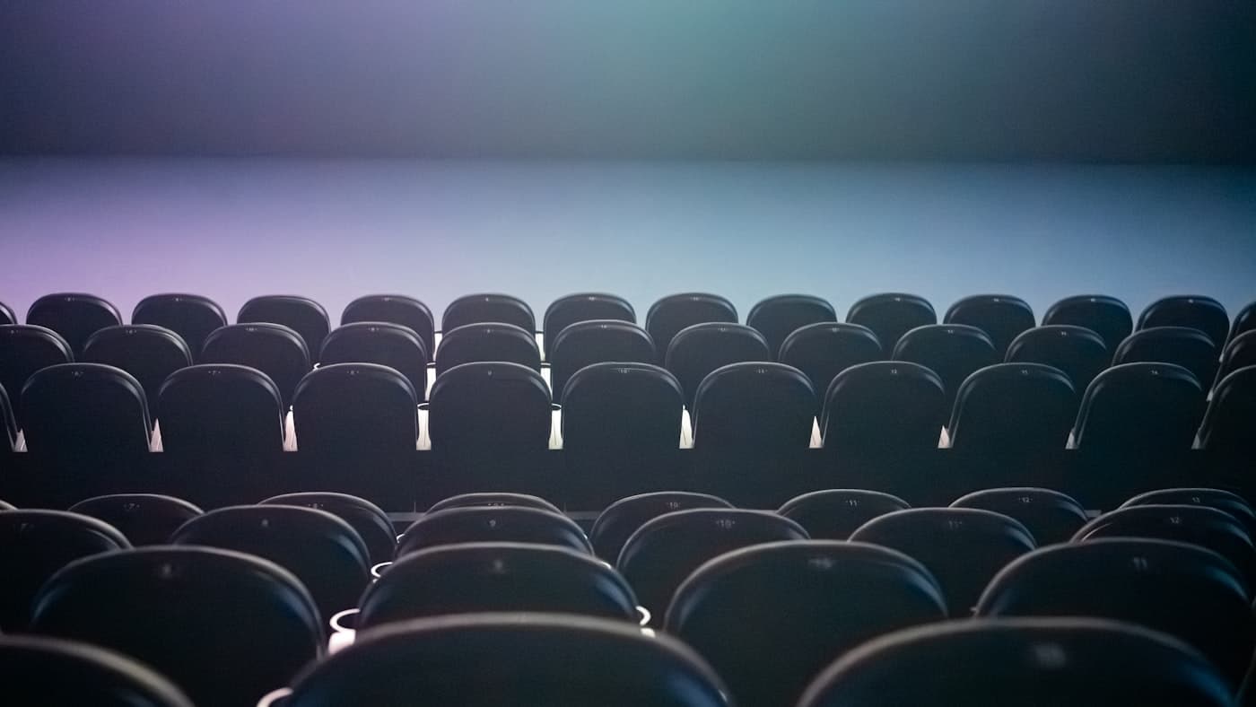 Rows of empty auditorium seats under soft lighting, representative of a large event